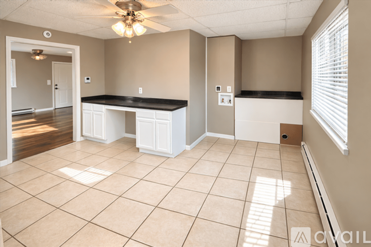 A room with a ceiling fan and tiled flooring.