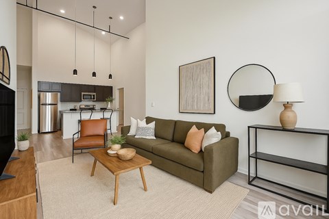 A modern living room with a green couch and a wooden coffee table.