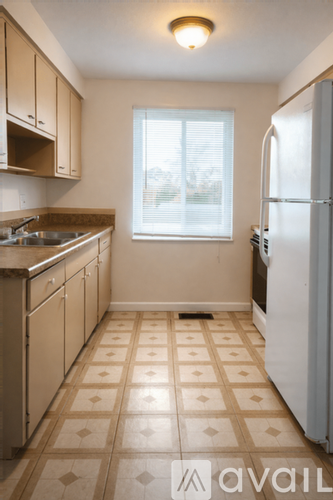 A kitchen with a tile floor and a refrigerator.