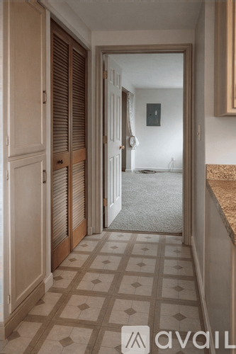 A hallway with a tiled floor and a door on the right.