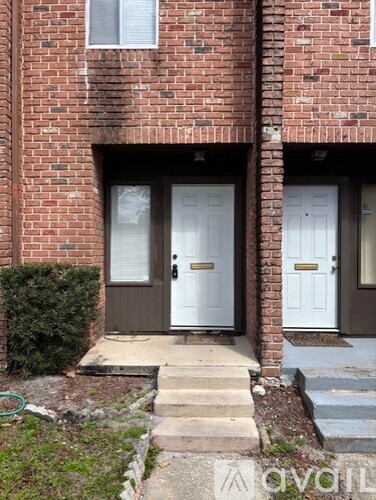 A brick house with a white door and a brown door.