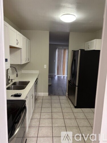 A kitchen with black appliances and white cabinets.