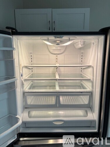 A white refrigerator with the door open and shelves inside.