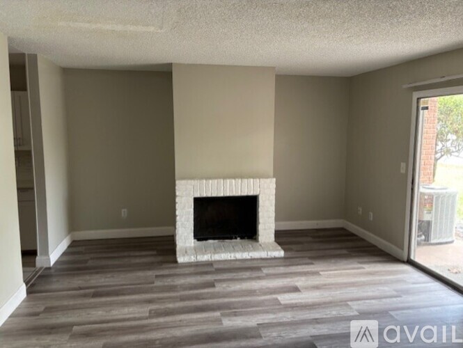 A living room with a fireplace and wood flooring.