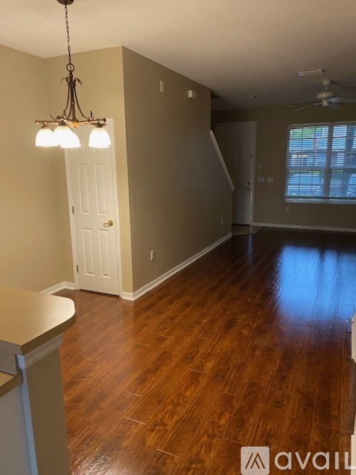 A room with wooden floors and a chandelier.