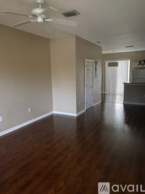 A room with wooden floors and a ceiling fan.