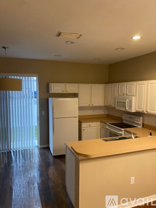 A kitchen with white cabinets and appliances.