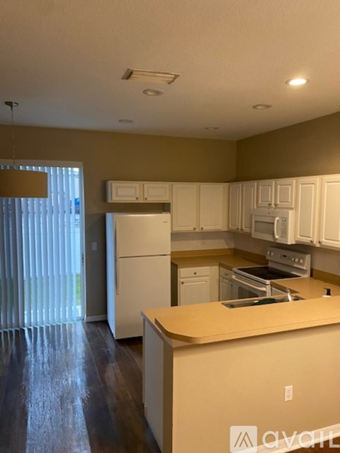 A kitchen with white cabinets and appliances.