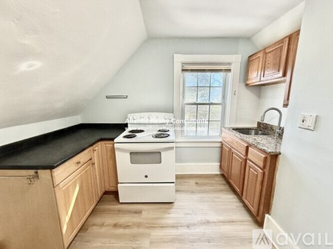 A kitchen with wooden cabinets and a black countertop.