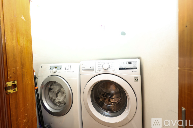 Two front loading washing machines in a small room.