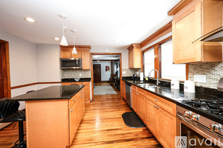 A kitchen with wooden cabinets and black countertops.