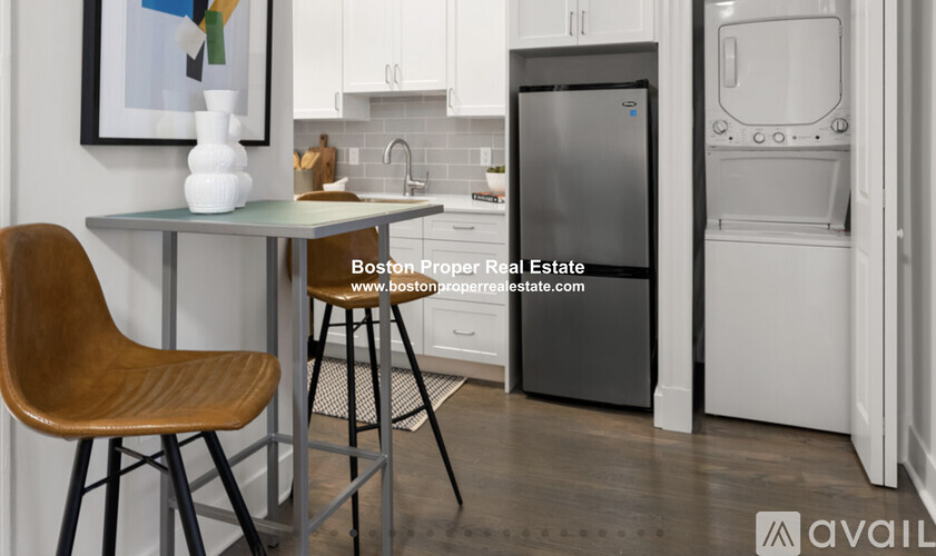A kitchen with a table and chairs and a fridge.