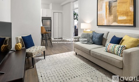 A living room with a couch, chair, and a painting on the wall.