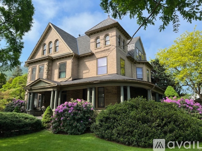 A large, two-story house with a gabled roof and a wrap-around porch.