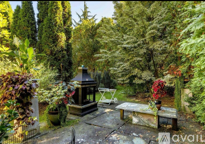 A garden with a gazebo surrounded by trees and plants.