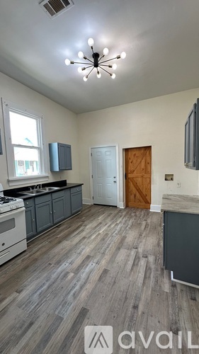 A kitchen with a wooden floor and a ceiling light.