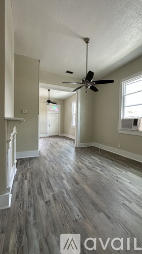 A room with a ceiling fan and wooden flooring.
