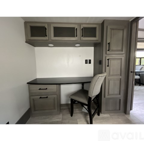 A kitchen with a table and chairs and a cabinet above it.