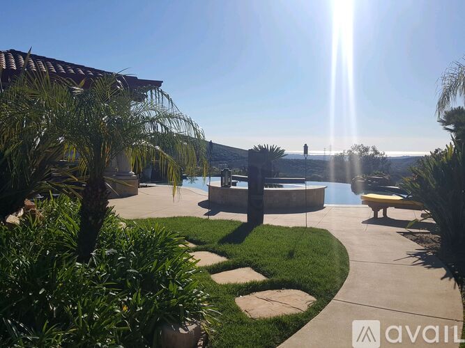 A sunny day at a poolside with a person standing in the distance.