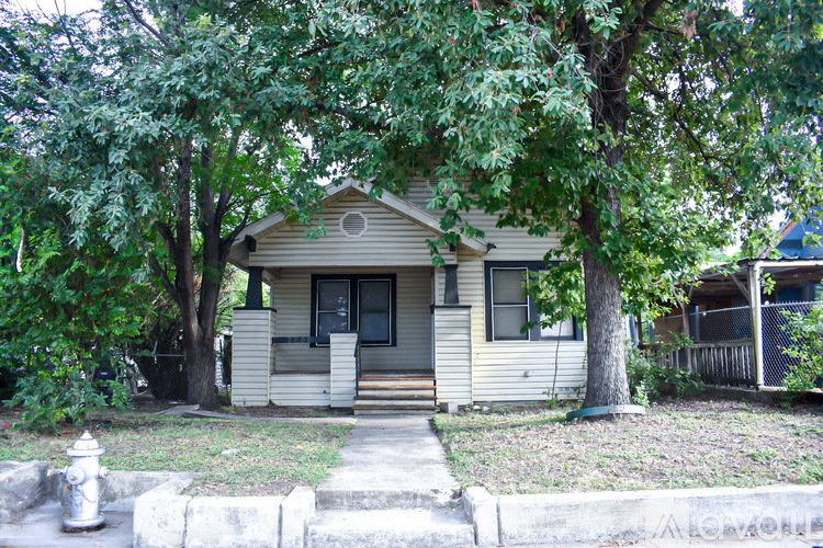 A small house with a tree in front of it.
