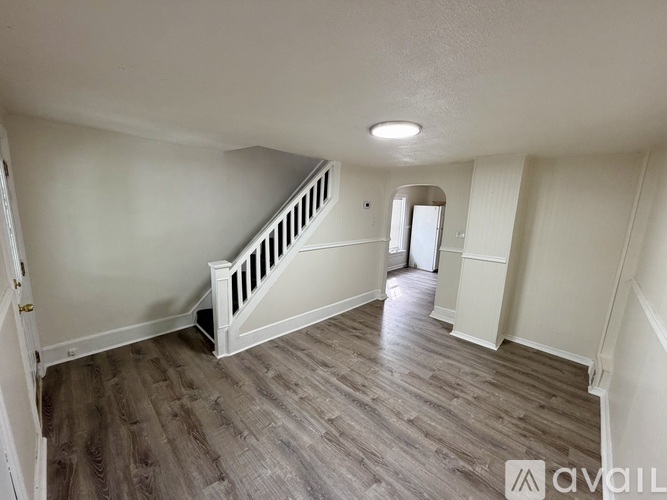 A room with wooden flooring and a staircase.