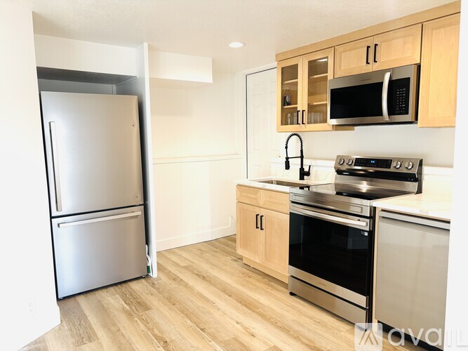 A kitchen with a stainless steel refrigerator, oven, and microwave.