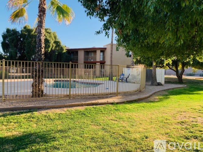 A fenced area with a pool and a building in the background.