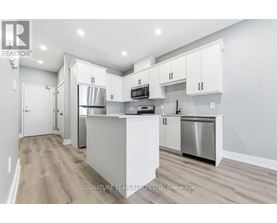 A modern kitchen with white cabinets and stainless steel appliances.