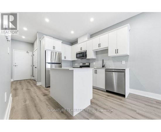 A modern kitchen with white cabinets and stainless steel appliances.