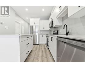 A modern kitchen with white cabinets and stainless steel appliances.