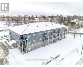 A large grey building with a snowy landscape in the foreground.