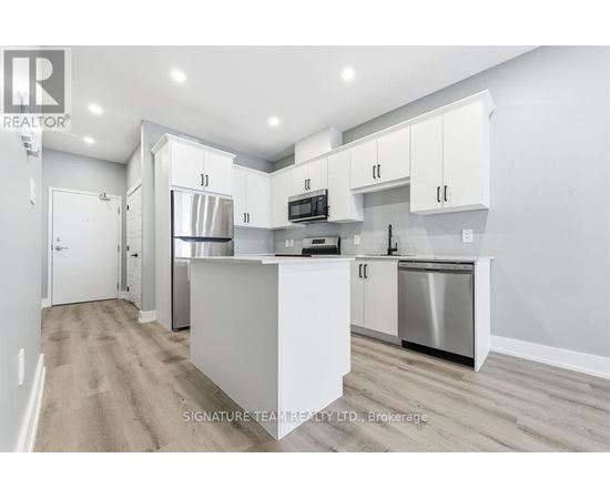 A modern kitchen with white cabinets and stainless steel appliances.