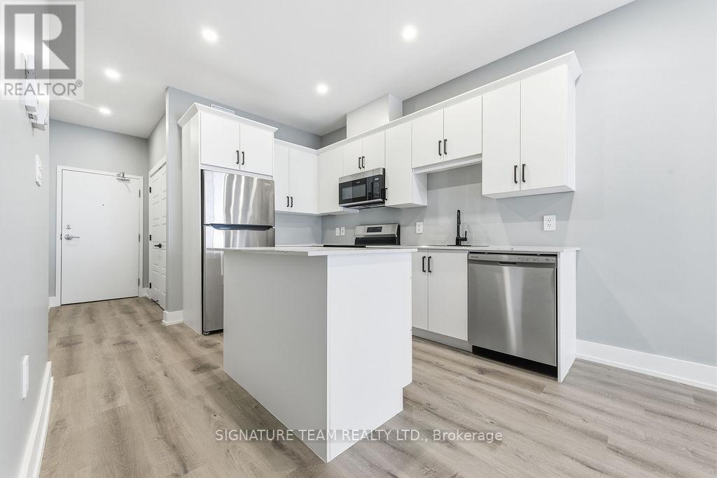 A modern kitchen with white cabinets and stainless steel appliances.