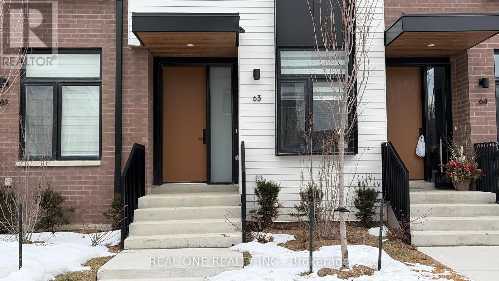 A house with a brown door and a sign that says "REAL ONE REALTOR".