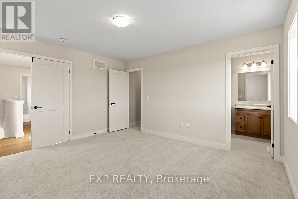 A white bedroom with a brokerage sign on the wall.
