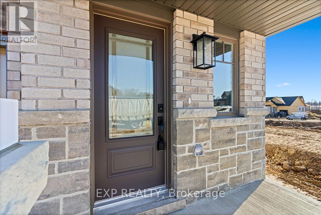 A house entrance with a brown door and a stone wall.