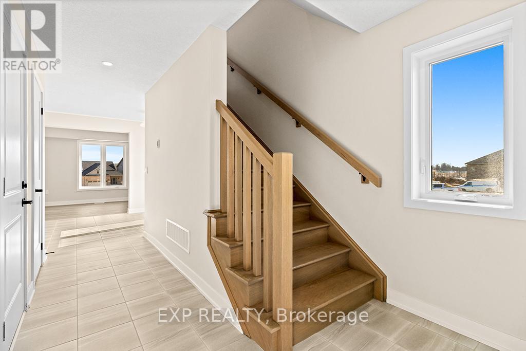 A well-lit, spacious hallway with a staircase leading to the second floor.