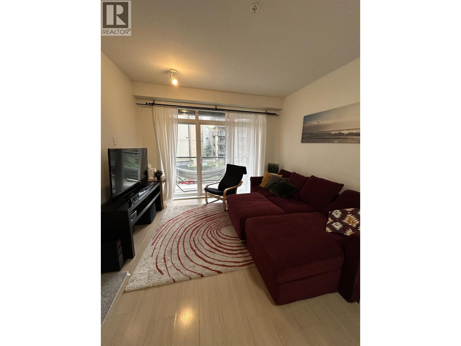 A living room with a red couch and a television.