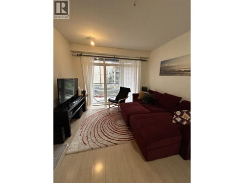 A living room with a red couch and a television.