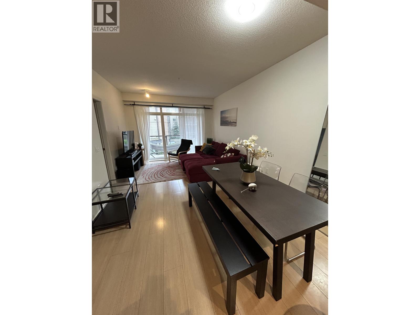 A living room with a black table and chairs.