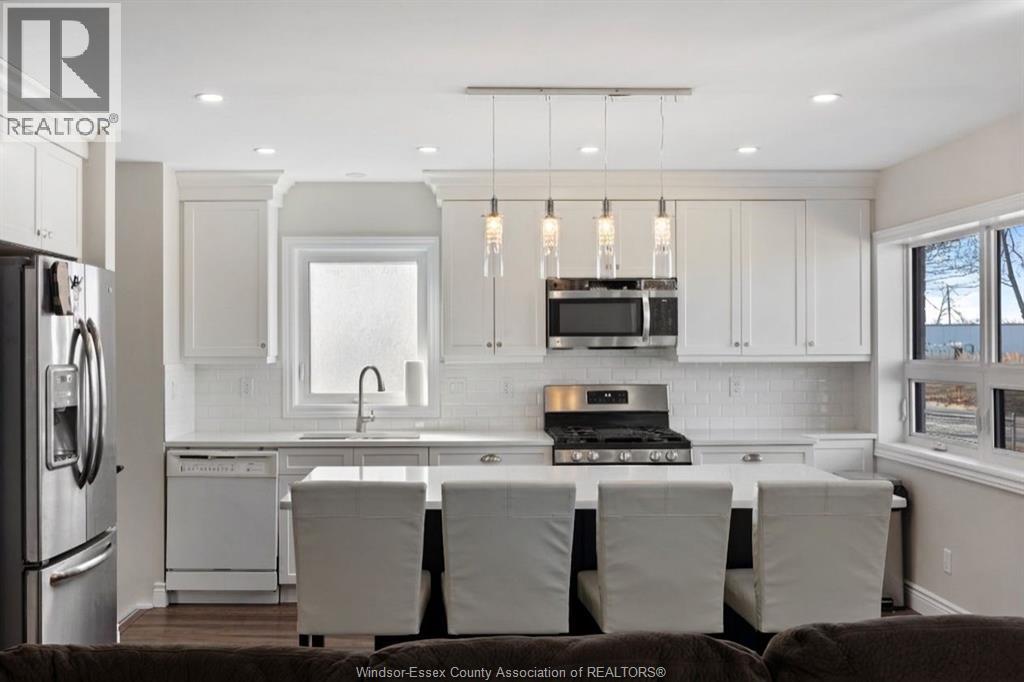 A kitchen with white cabinets and a refrigerator.