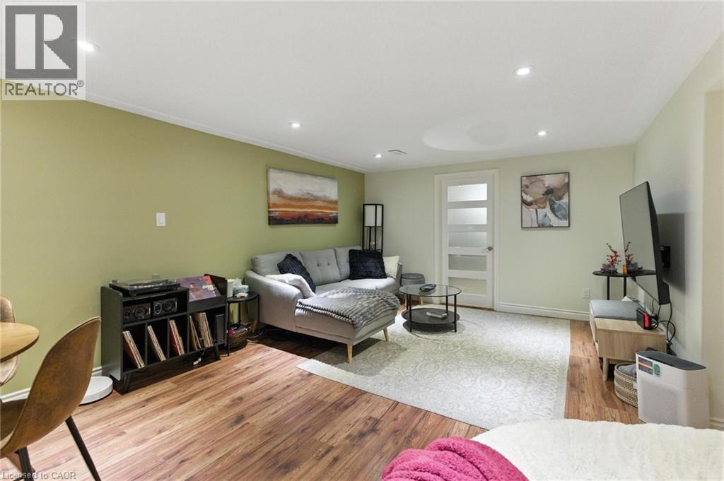 A bedroom with a bed, a chair, and a painting on the wall.