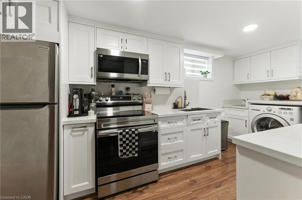 A modern kitchen with white cabinets and stainless steel appliances.