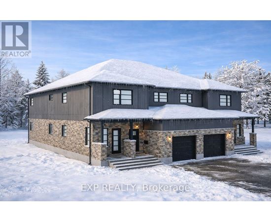 A large house with a stone wall and a black roof covered in snow.