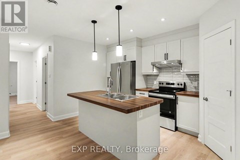 A modern kitchen with white cabinets and a wooden island.