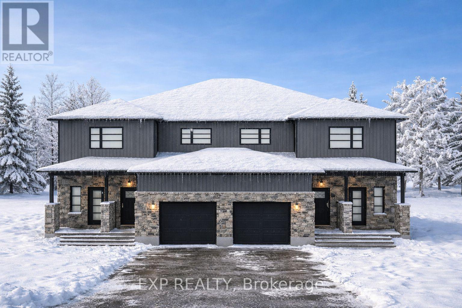 A large house with a snowy roof and garage doors.