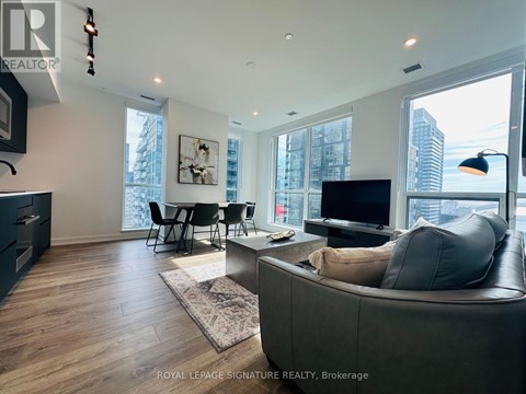 A modern living room with a grey couch and a television.