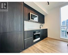 A modern kitchen with dark wood cabinets and a white countertop.