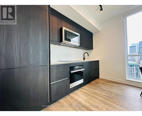 A modern kitchen with dark wood cabinets and a white countertop.