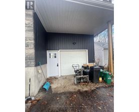 A garage with a white door and a black wall.